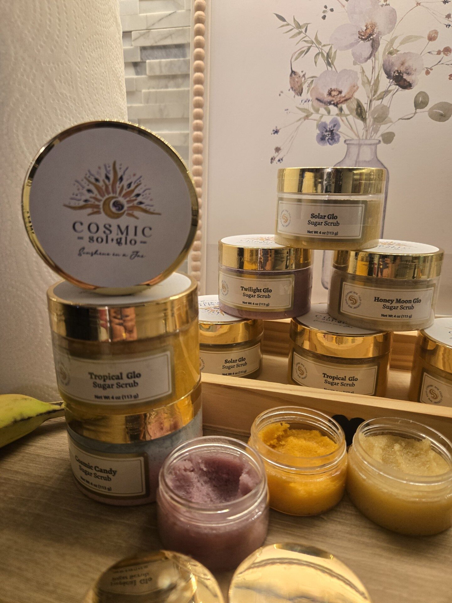 All five Cosmic Sol Glo scrubs with open jars showing their colorful textures