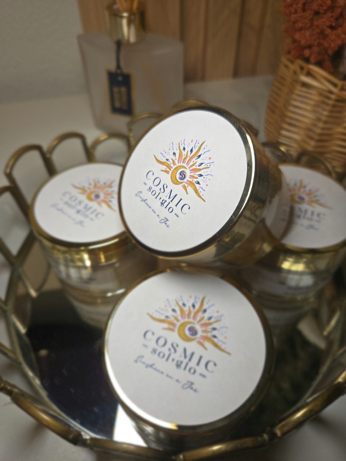 Top-down view of Cosmic Sol Glo gold-lidded jars arranged in a gold scalloped tray